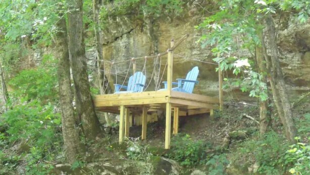 A wooden deck with two Adirondack chairs in a forested area. - Summertime and the living is easy at the bearclaw  (Springville)