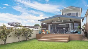 A modern two-story house with a covered patio, a swimming pool, and a fenced backyard. - Sunset Central Coast - Lake, Kayaks & Jetty! (Mannering Park)