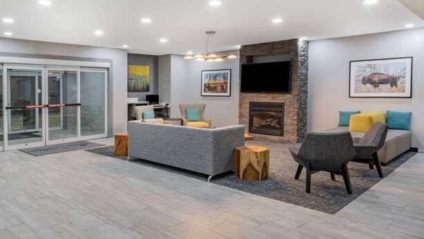 A modern living room with a fireplace, comfortable seating, and a television.