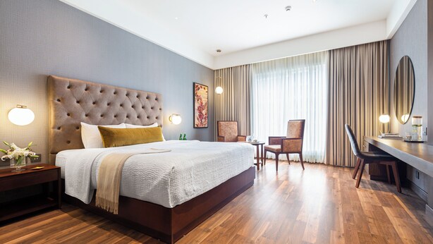 A modern hotel room with a large bed, a desk, and a chair. - Wyndham Chandigarh Mohali (Mohali)