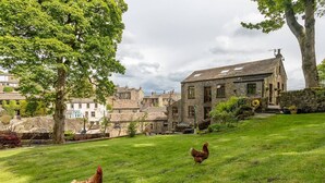 A rural setting with stone buildings, a grassy area, and two chickens. - OldMill-2Bed-Sleeps6-PrivateGarden-OptionalHotTub (Keighley)