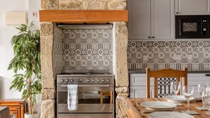 A kitchen with a built-in oven, a wooden table set for dining, and a potted plant. - OldMill-2Bed-Sleeps6-PrivateGarden-OptionalHotTub (Keighley)