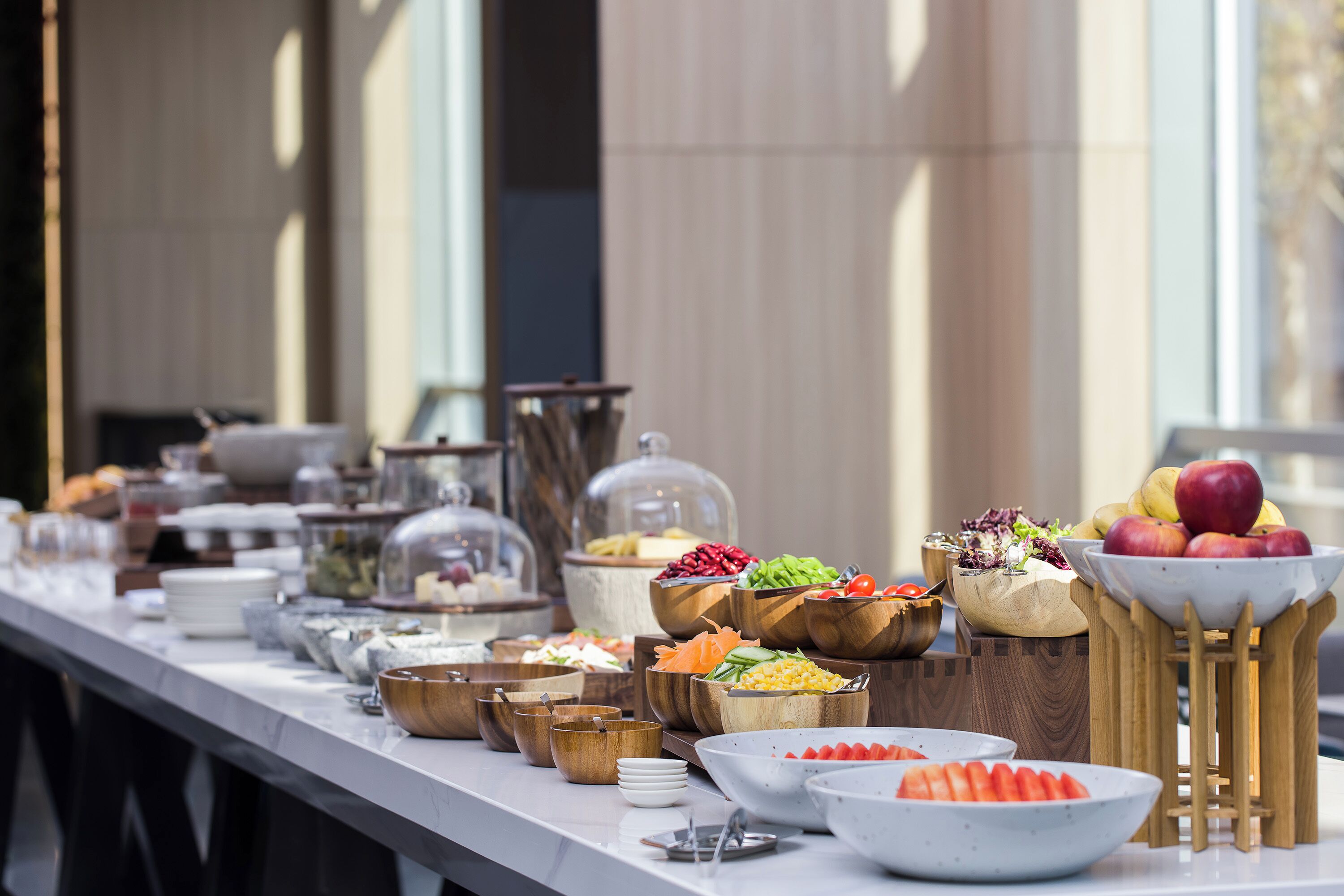 A buffet table with various food items and utensils.