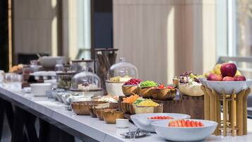 A buffet table with various food items and utensils.