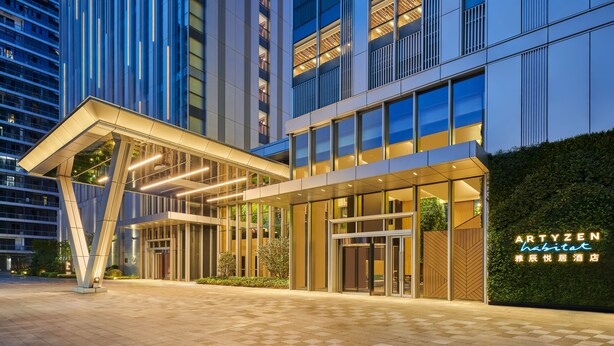 A modern hotel entrance with a glass facade, a covered walkway, and a neon sign. - Artyzen Habitat Qiantan Shanghai   (Shanghai)