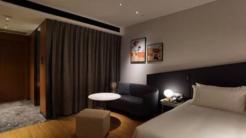 A hotel room with a bed, a desk with a lamp, a chair, a small table, and a large window with curtains.