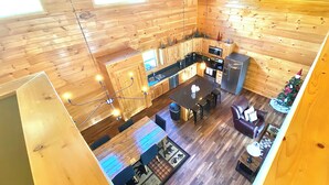 A wooden cabin interior with a kitchen, dining area, and a small living space. - Modern cabin with mountain views, just minutes from local attractions (Gatlinburg)