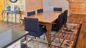 A dining area with a wooden table and chairs, a chandelier, and a wooden ceiling. - Modern cabin with mountain views, just minutes from local attractions (Gatlinburg)