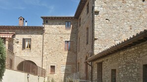 Ein Gebäude aus Stein mit mehreren Fenstern und Balkonen, das einen traditionellen Baustil zeigt.