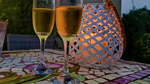 Dos copas de champán sobre una mesa con baldosas y un farol decorativo al fondo.