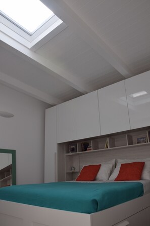 A bedroom with a skylight, white wardrobe, and a bed with teal bedding. - Deluxe Dependance Living Roo-deluxe Soggiorno In Dependance Con Piscina Privata (San Giovanni la Punta)
