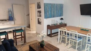 Un salon comprenant un canapé, une table basse et un coin repas avec des chaises et une table.