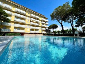 Une piscine avec un bâtiment en arrière-plan.
