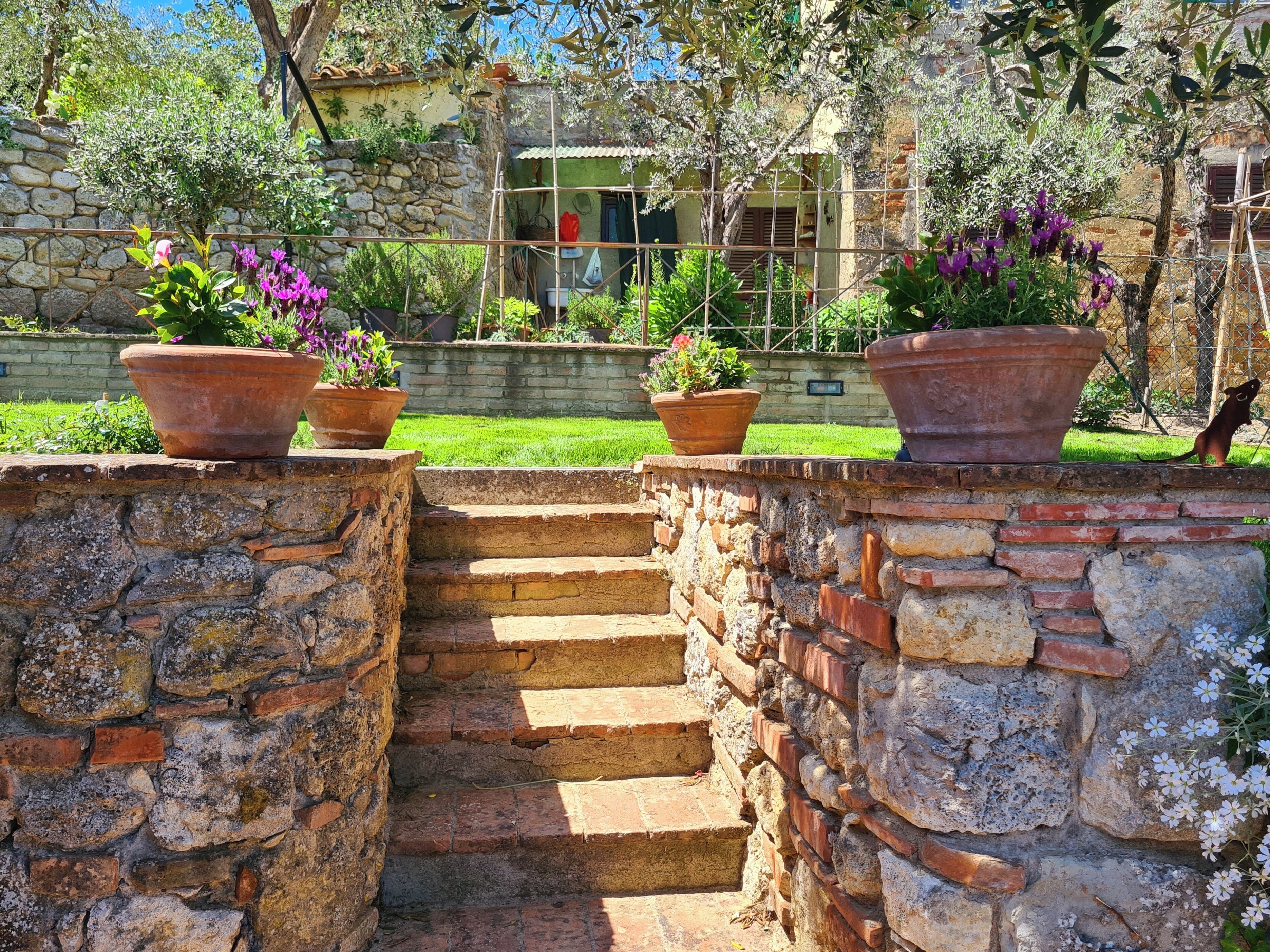 A stone staircase leading to a house with a garden.