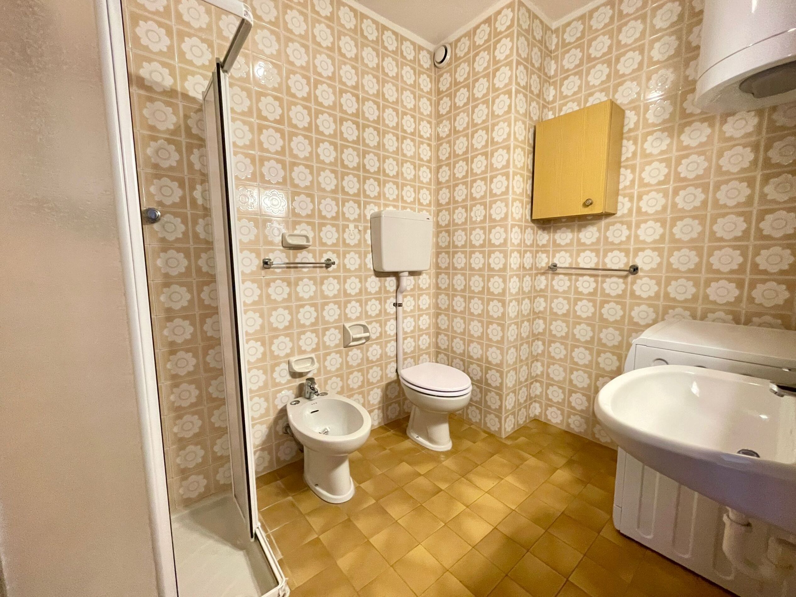 A bathroom with a toilet, bidet, and sink.