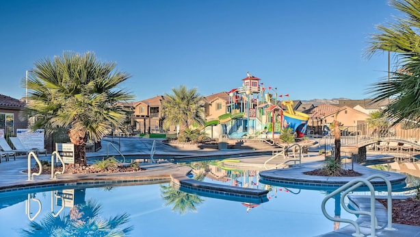 A pool area with a clear view of a building with a red roof and a blue structure with a flag.