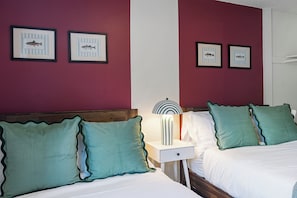 A hotel room with two beds, a nightstand, a lamp, and framed fish pictures on the wall. - Lake Views - Game Room/Movie Room - Seattle (Seattle)