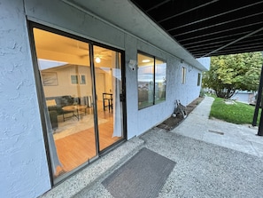 A modern building with large sliding glass doors leading to a living area with a sofa and a coffee table. - Lake Views - Game Room/Movie Room - Seattle (Seattle)