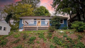 A two-story house with a wooden deck and a front porch.
