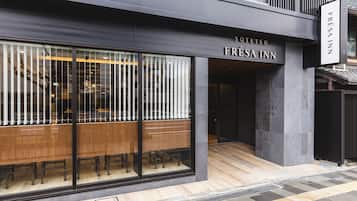 A modern building with a restaurant named "Fresa Inn" on the ground floor.