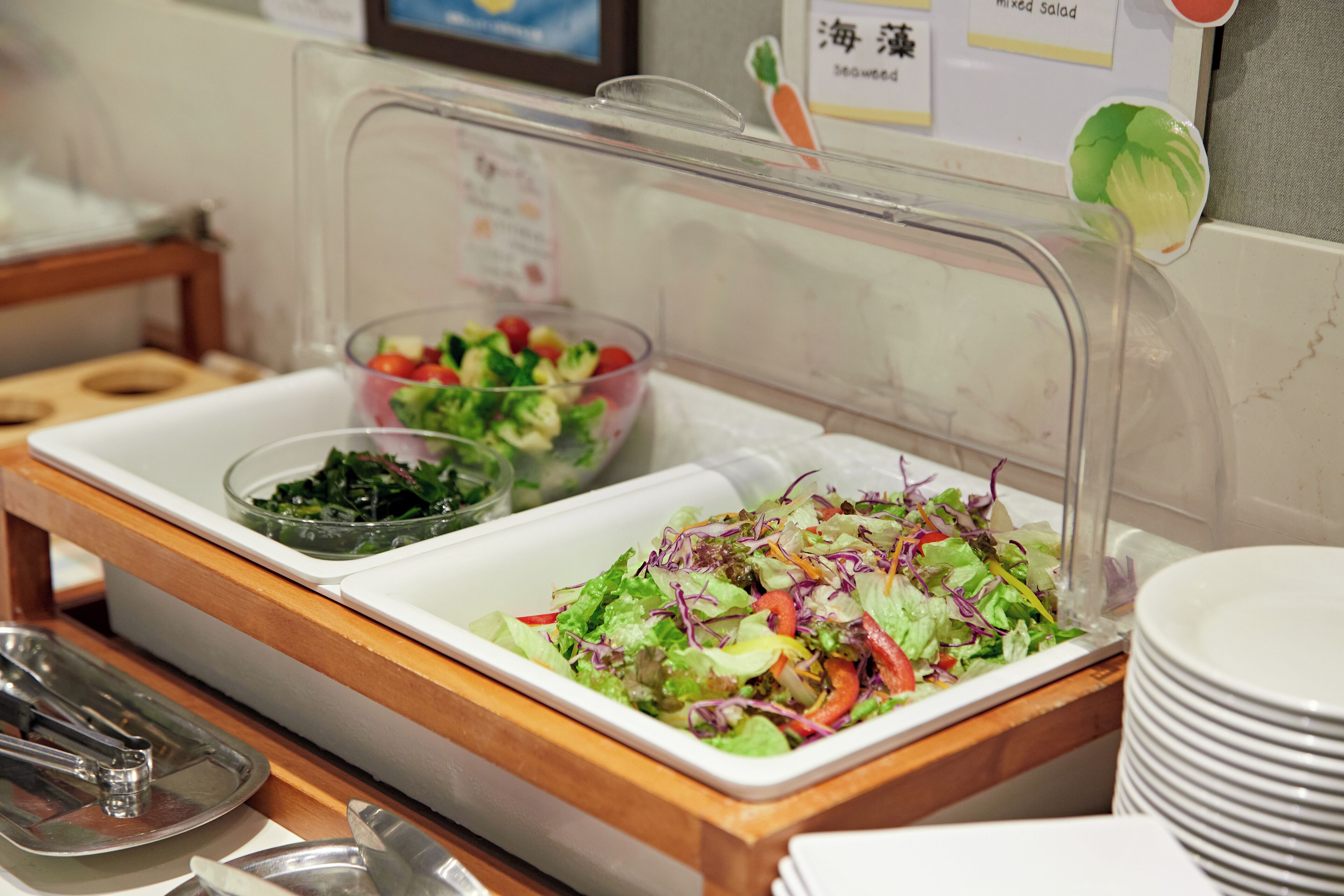 A buffet with various salads and a salad bar.