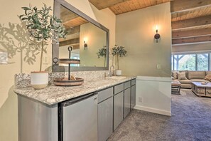 Modern kitchen with granite countertop, stainless steel appliances, and a large mirror.