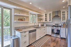Enjoy cooking in this well-lit kitchen with a double sink, oven, and stainless steel dishwasher.