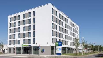 A modern hotel with a white facade, multiple windows, and a Holiday Inn Express sign.