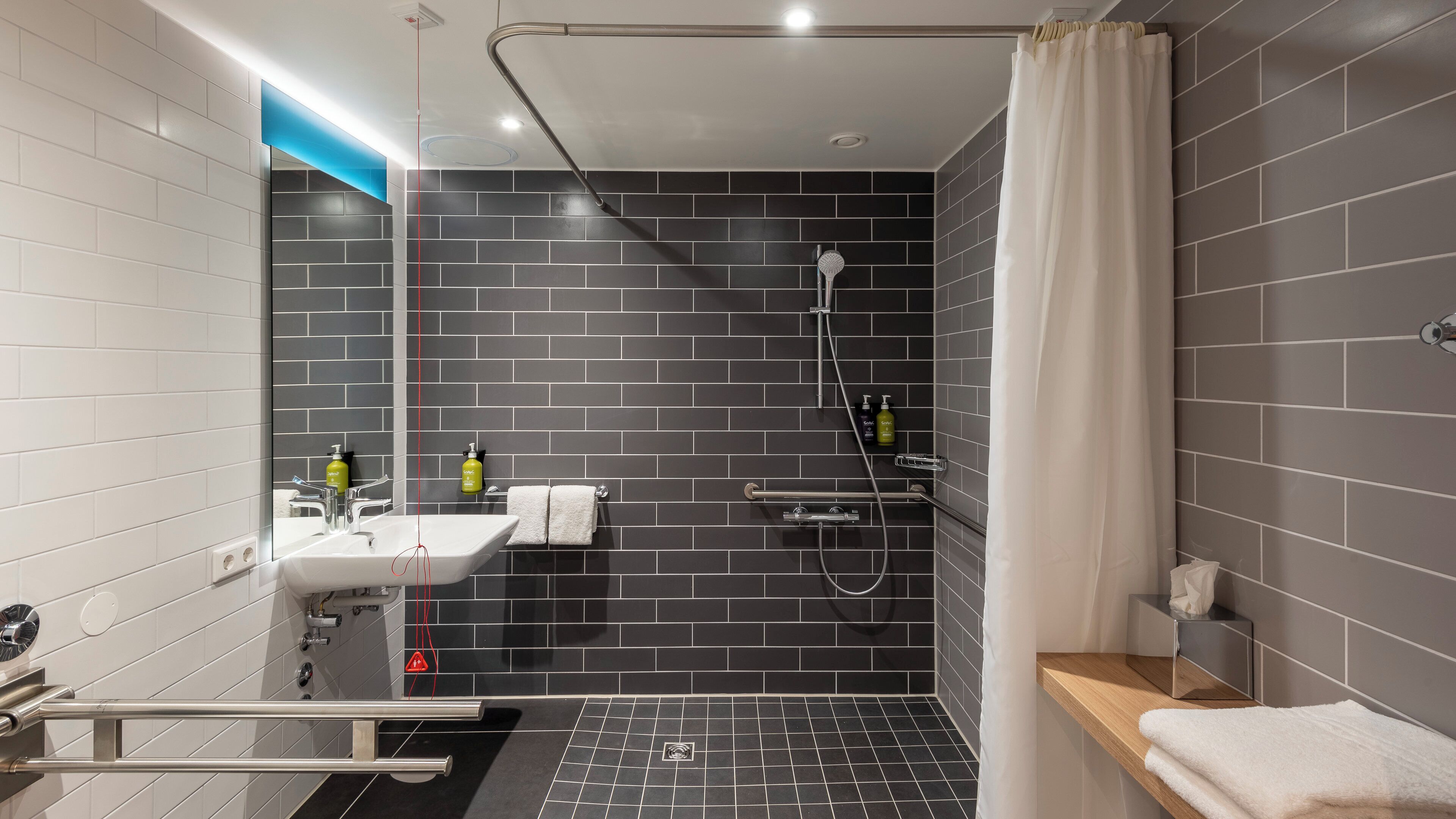 A modern bathroom with a shower, sink, and toilet.
