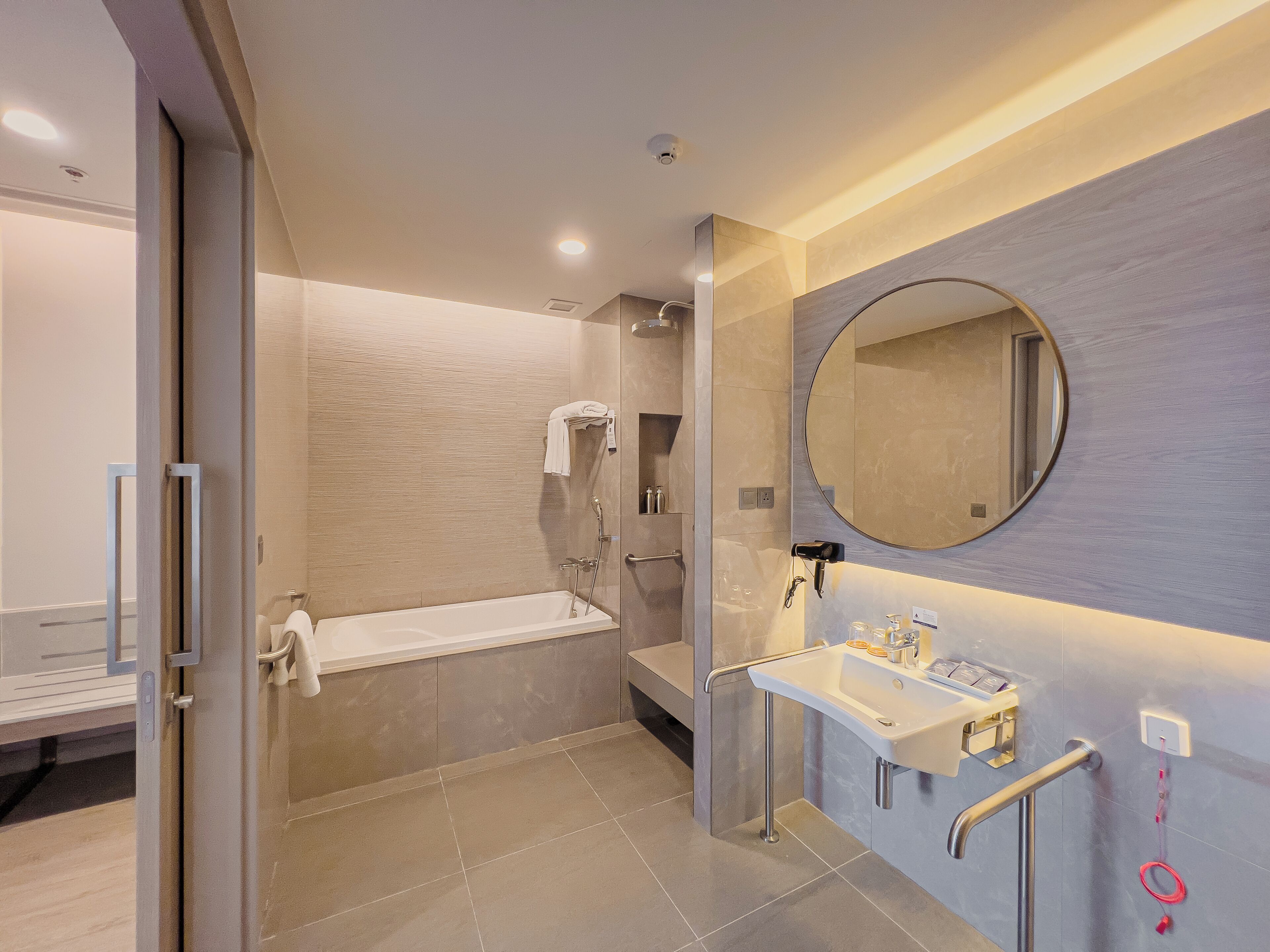 Un baño moderno con bañera, lavamanos con espejo y cabina de ducha.