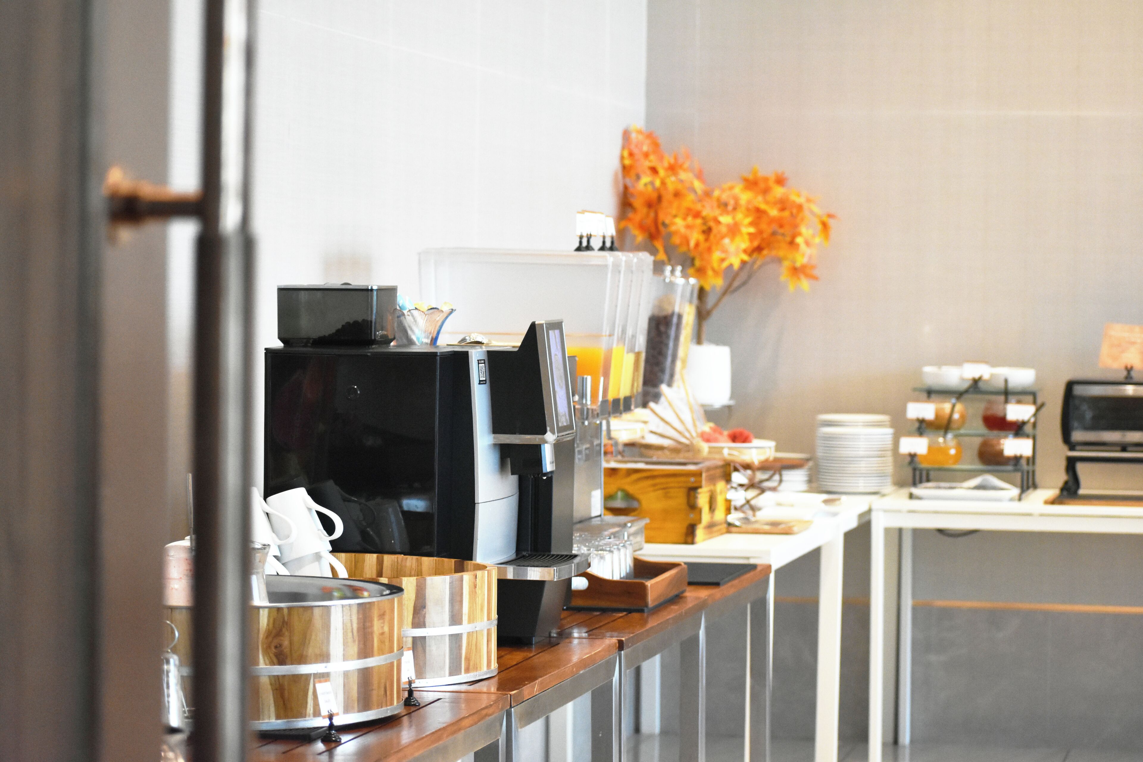 Disposição de buffet com máquina de café, dosadores de temperos e diversas opções de comida.