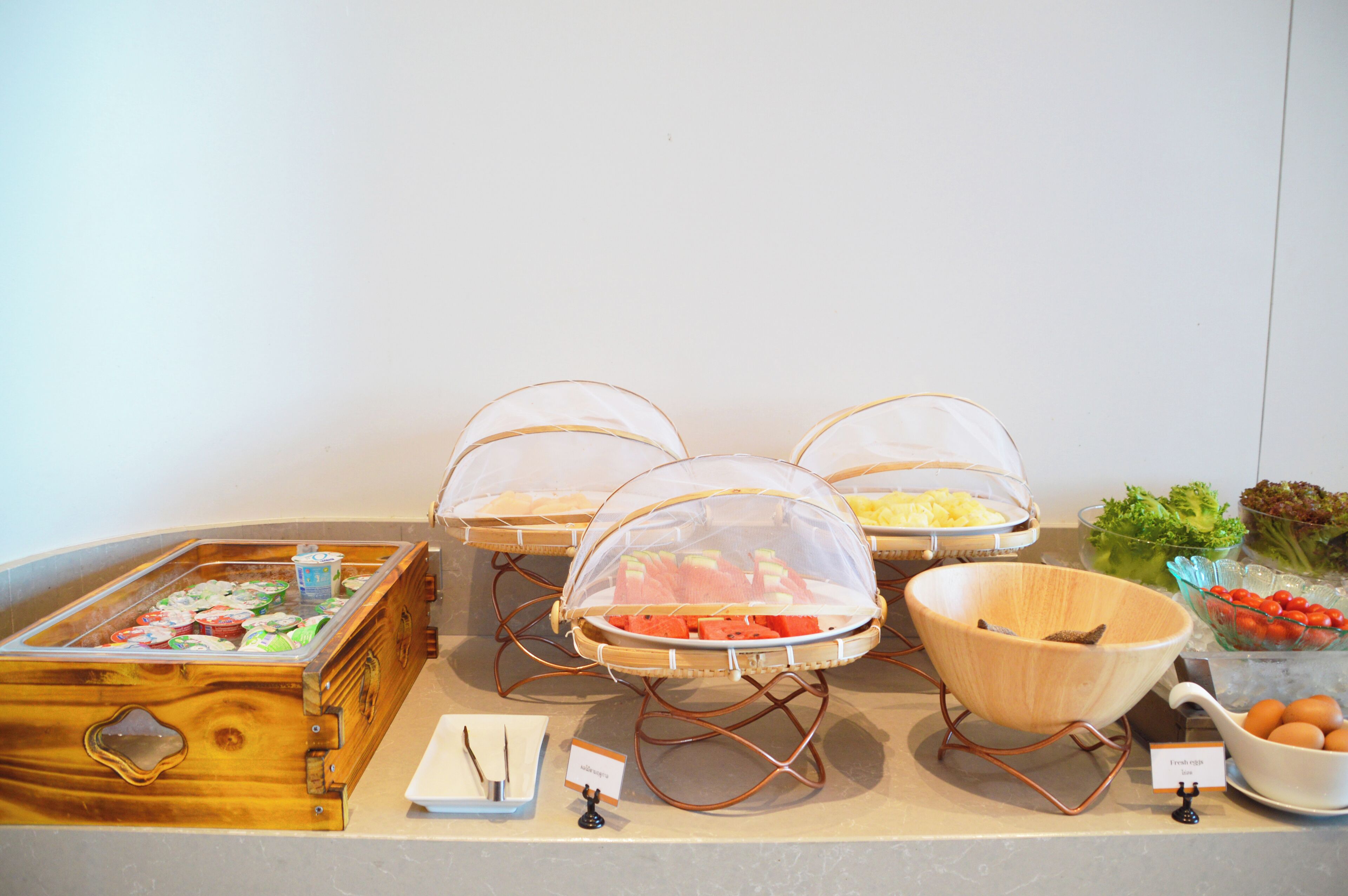 A buffet setup with various food items and serving utensils.