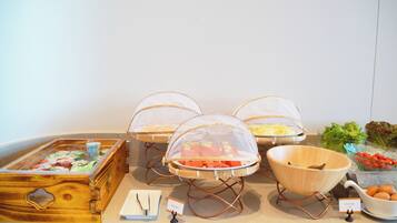 A buffet setup with various food items and serving utensils.