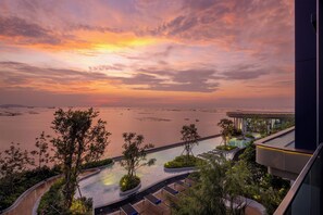 A resort with a pool, lush greenery, and a view of the water. - S. Sriracha Hotel and Residence (Si Racha)