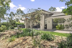 A modern house with a patio, a barbecue area, and a garden with various plants. - FAIRWAY & VINES - THE VINTAGE HOLIDAY HOUSES (Rothbury)