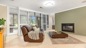 Ein Wohnzimmer mit braunem Ledersofa, einem Couchtisch und einem Kamin.