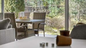A wicker dining set with a white table and chairs, a coffee pot, and a tray with cups and a spoon. - Amazing home in Nexø with WiFi (Nexø)