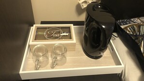 Eine Schublade mit einer schwarzen Kaffeemaschine, zwei Glasbehältern und einer Schachtel mit Namensschild.