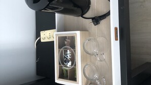 Ein kleines Zimmer mit Etagenbett, einem Einbauschrank mit Glastür und einem angesteckten Föhn.