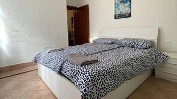 Ein Schlafzimmer mit einem Bett, einer Kandelaber und einem Gemälde an der Wand.