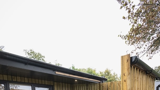 Een hottub in een houten terrasgedeelte met een raam en een houten omheining.