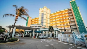 Ein mehrgeschossiges Hotel mit einem zentralen Atrium, einem Parkplatz und einem verschlossenen Eingang.