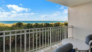 Ein Balkon mit Blick auf Strand und Meer.