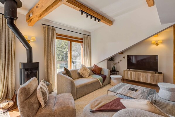 Una sala de estar acogedora con chimenea, asientos cómodos y televisor.