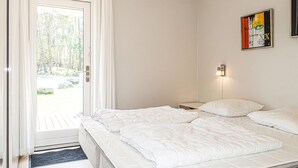 Une chambre avec un lit, une porte donnant sur un balcon et un luminaire fixé au mur.
