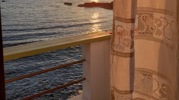 A balcony with a view of the sea at sunset. - Milos By The Sea – Seafront House (Milos)