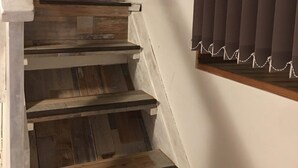 Een houten trap met een stuurwieldecoratie bovenaan.