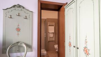 Une salle de bain avec douche, toilettes et porte-serviettes.