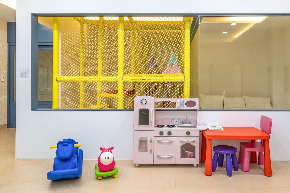 A children's play area with a play kitchen, a toy car, and a toy horse.