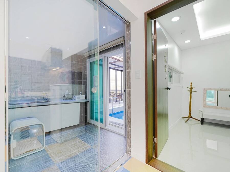 Casa de banho moderna com divisória de vidro, lavatório e sanita.